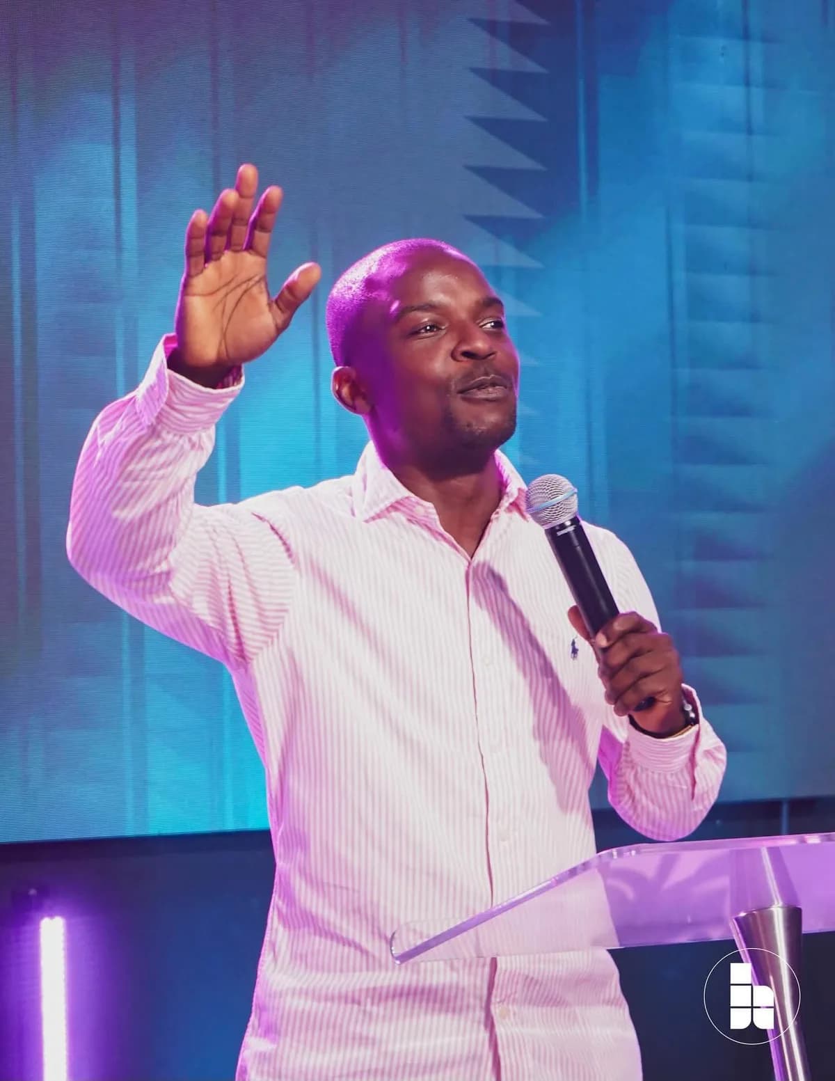 A pastor preaching with a raised hand during a Sunday service
