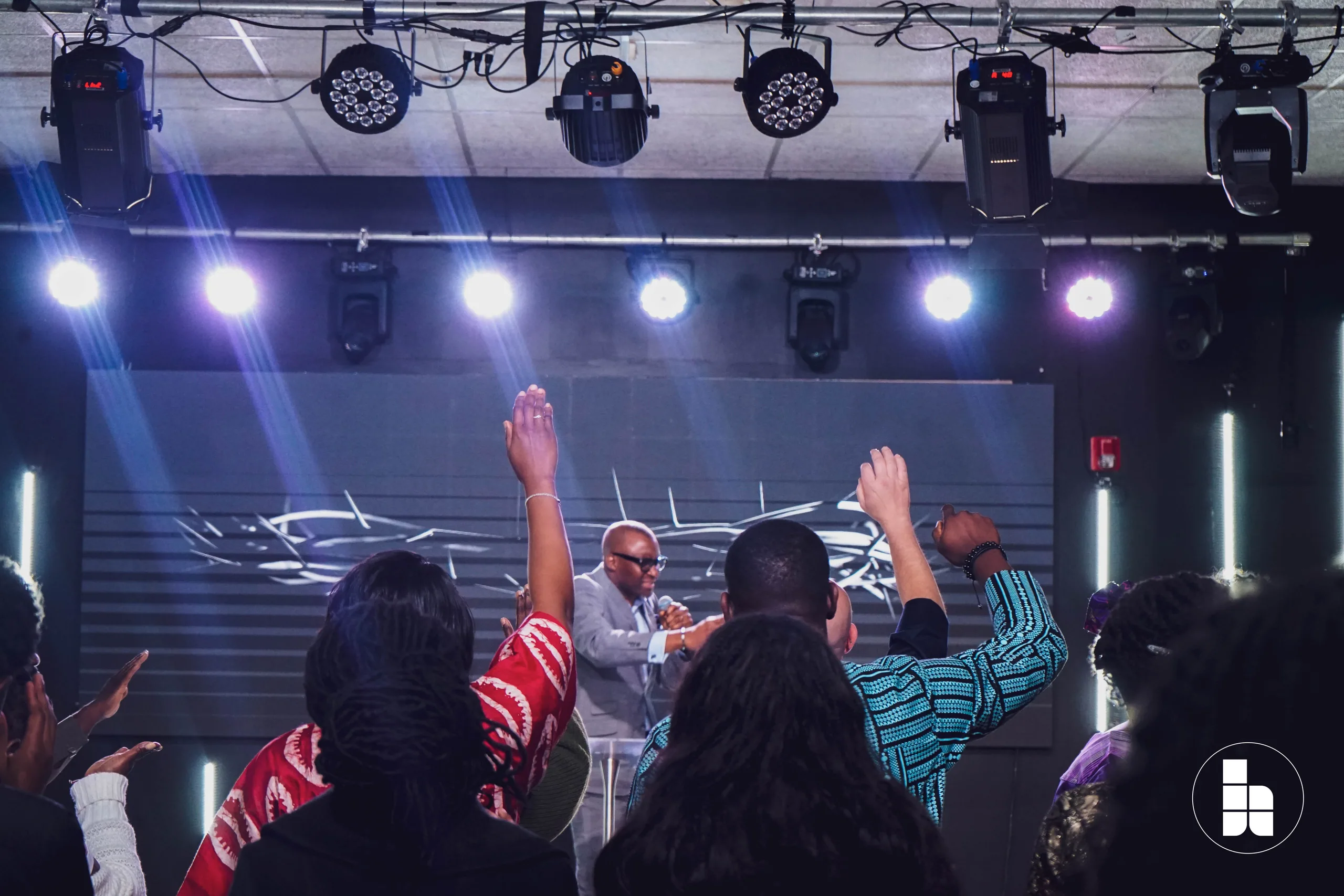 The congregation with hands raised during a Sunday service at Jubilee Place